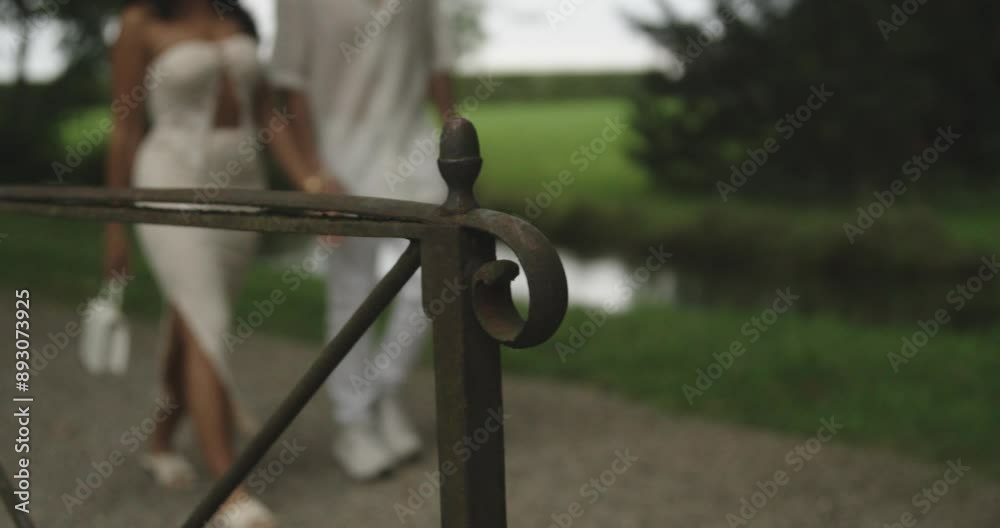 A couple with white outfit walking in the park and holding hands A couple with white outfit walking in the park and holding hands