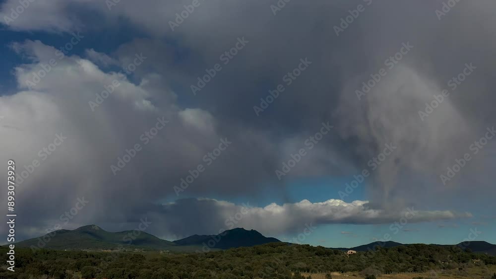flight with a drone in a mountain area where we visualize a beautiful sky with blue brushstrokes and large cotton-shaped storm clouds where curtains of water appear discharging flight with a drone in a mountain area where we visualize a beautiful sky with blue brushstrokes and large cotton-shaped storm clouds where curtains of water appear discharging