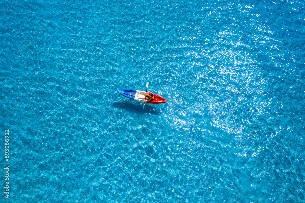 Aerial view of a kayak in the blue sea .man kayaking he does water sports activities. Aerial view of a kayak in the blue sea .man kayaking he does water sports activities.