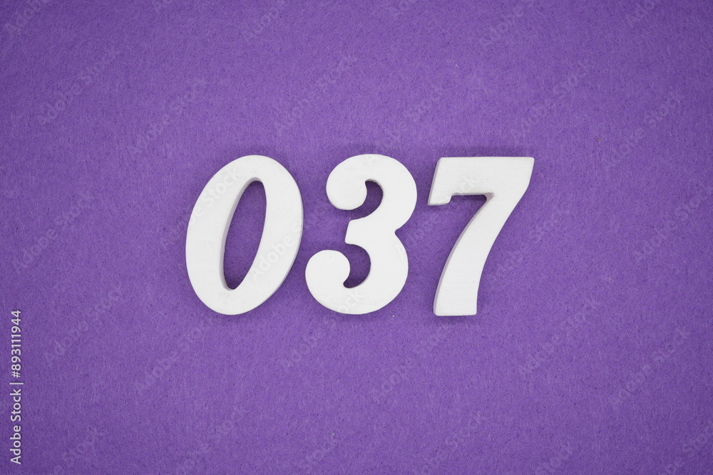 The numbers are made of white paint wood, placed on the background as a purple paper. The numbers are made of white paint wood, placed on the background as a purple paper.
