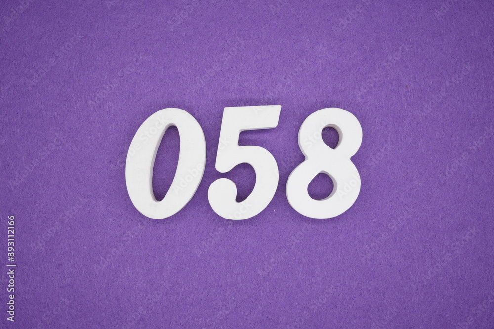 The numbers are made of white paint wood, placed on the background as a purple paper. The numbers are made of white paint wood, placed on the background as a purple paper.