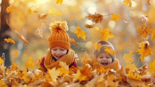 Two young children in cozy autumn clothes playing in a pile of leaves, smiling and enjoying a sunny fall day.