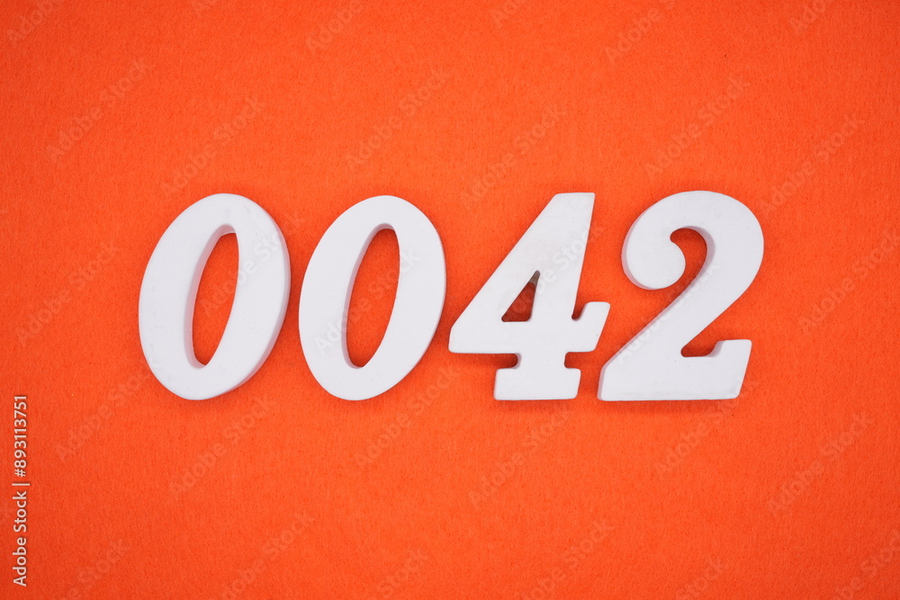 The numbers are made of white painted wood. Placed on the floor was orange paper. The numbers are made of white painted wood. Placed on the floor was orange paper.