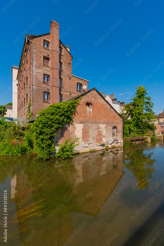 Louviers, France 07 19 2024 : Red brick building along the Eure river in the Center of Louvier in Normandy Louviers, France 07 19 2024 : Red brick building along the Eure river in the Center of Louvier in Normandy