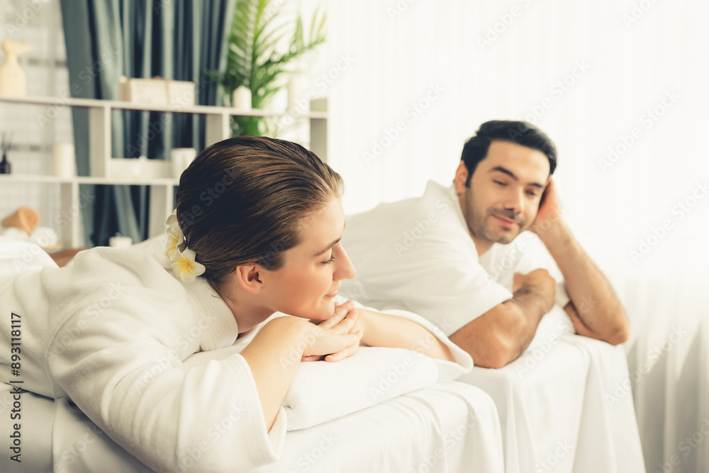 Caucasian couple customer enjoying relaxing anti-stress spa massage and pampering with beauty skin recreation leisure in day light ambient salon spa at luxury resort or hotel. Quiescent Caucasian couple customer enjoying relaxing anti-stress spa massage and pampering with beauty skin recreation leisure in day light ambient salon spa at luxury resort or hotel. Quiescent