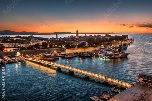 Zadar, Croatia - Aerial view of the city of Zadar at golden sunset sky with illuminated City Bridge (Gradski most), Cathedral of St. Anastasia tower and yacht marina