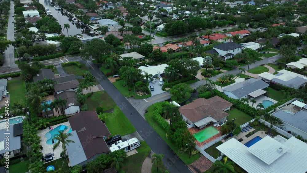 Upscale Neighborhood in Florida with swimming pool in garden during rainy day. Villa and Mansion with river in suburb of Fort Lauderdale, USA. Aerial flyover shot. Upscale Neighborhood in Florida with swimming pool in garden during rainy day. Villa and Mansion with river in suburb of Fort Lauderdale, USA. Aerial flyover shot.