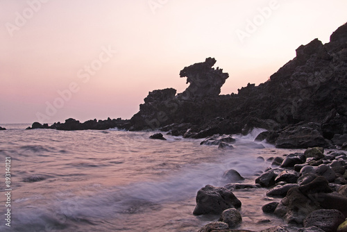 Morning view of wave on sea rocks against Yongduam Rock and horizon at Jeju-si, Jeju-do, South Korea
 photo