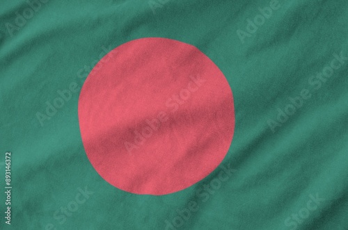 Bangladesh flag depicted on folded wavy fabric of old cloth close up photo