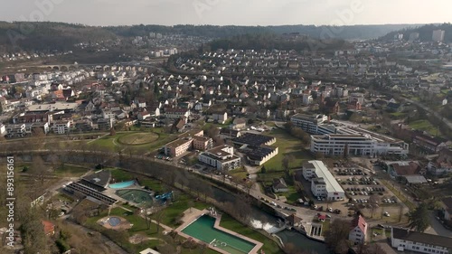 Aerial footage of Nagold in Baden-Württemberg. Flyover over river Nagold and local swimming pool. Panoramic view of houses and green area. photo