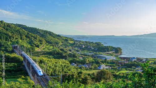 高速道路建設前の有明海の夕日を浴びて激走する九州新幹線