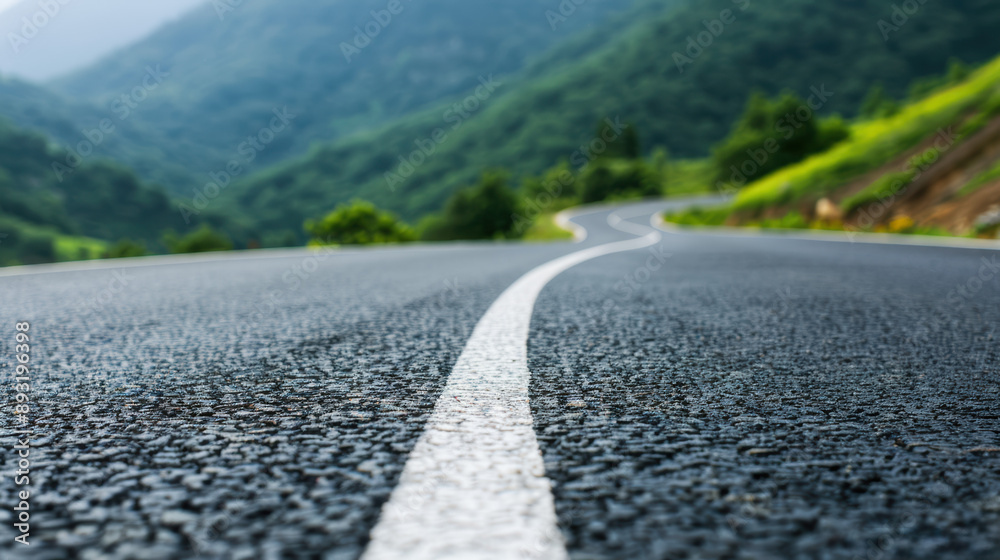 A winding road curves through a lush green mountain landscape, capturing the essence of adventure and natural beauty on a serene day. A winding road curves through a lush green mountain landscape, capturing the essence of adventure and natural beauty on a serene day.