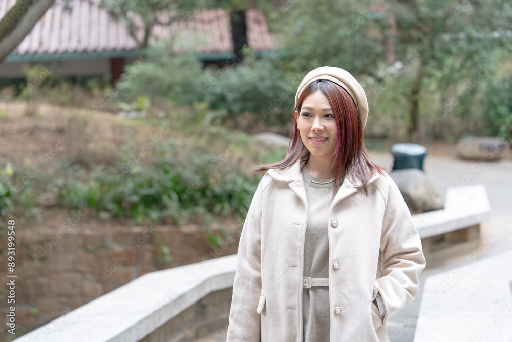 Thirty-something Hong Kong woman with reddish-brown hair standing in Kowloon Park, Tsim Sha Tsui, Kowloon Island, Hong Kong. Thirty-something Hong Kong woman with reddish-brown hair standing in Kowloon Park, Tsim Sha Tsui, Kowloon Island, Hong Kong.