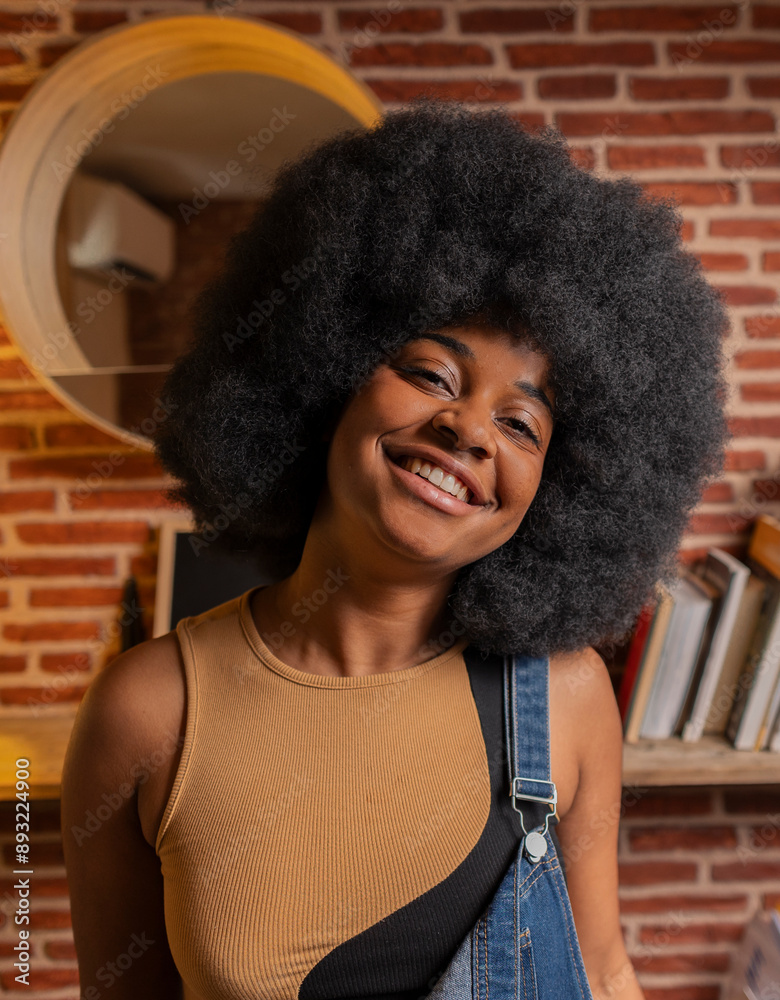Smiling young woman with Afro hairstyle at home Smiling young woman with Afro hairstyle at home