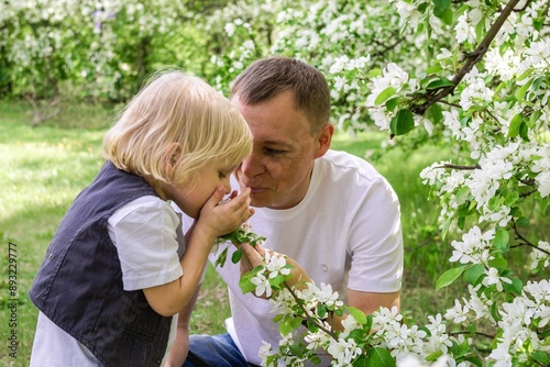 Father and Son Enjoying a Beautiful Moment in the Flower-Filled Garden Under the Warm Sunlight.