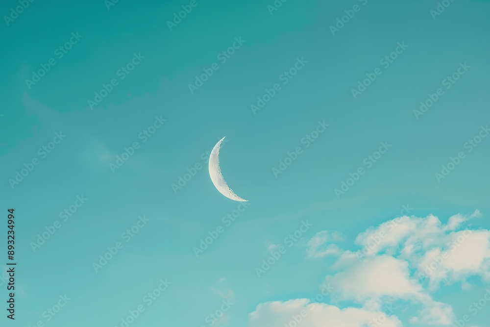 A photo of a crescent moon in a clear blue sky, simple and minimalistic. The stock photo has a simple composition with a feminine and sunny light background. A photo of a crescent moon in a clear blue sky, simple and minimalistic. The stock photo has a simple composition with a feminine and sunny light background.