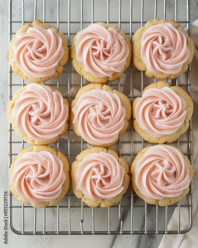 Top view of Crumbl cookies with pink frosting on a cooling rack, showcasing their beautiful decoration. photo