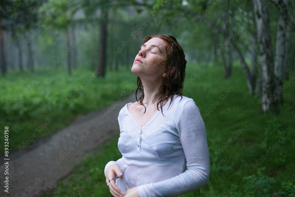Carefree woman with eyes closed enjoying rain in forest Carefree woman with eyes closed enjoying rain in forest