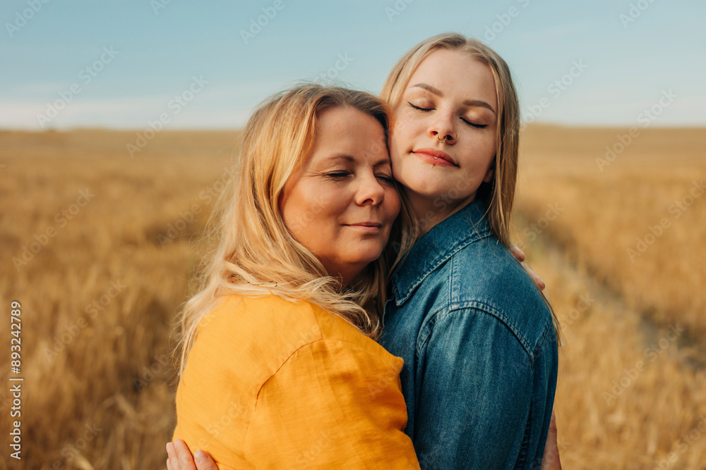 Mother embracing daughter in wheat field Mother embracing daughter in wheat field