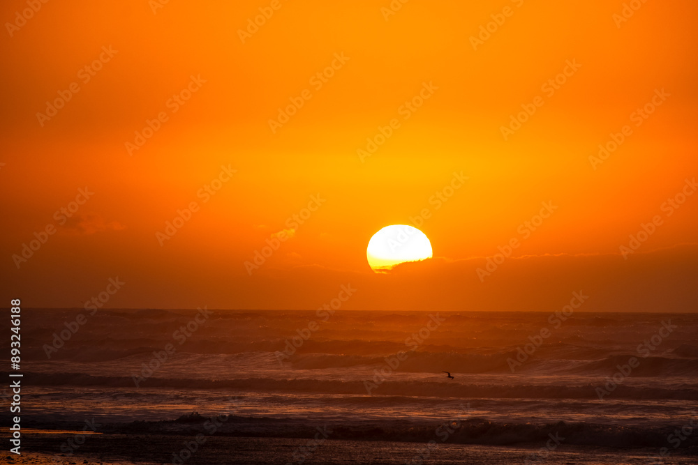 The golden sun sets over the ocean, casting a warm, glowing light on the waves and sky, creating a tranquil and beautiful scene. The golden sun sets over the ocean, casting a warm, glowing light on the waves and sky, creating a tranquil and beautiful scene.