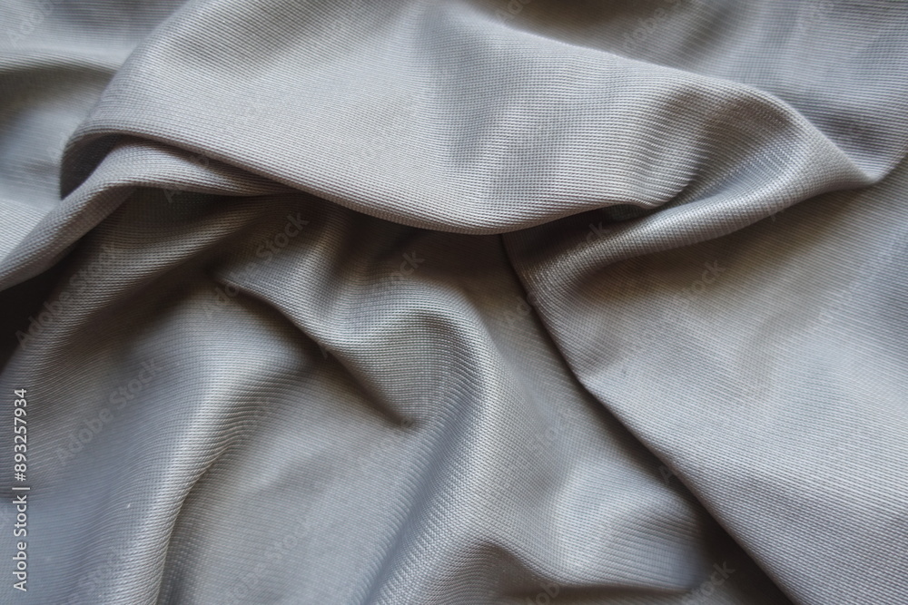 unprinted grey polyamide fabric in soft folds unprinted grey polyamide fabric in soft folds