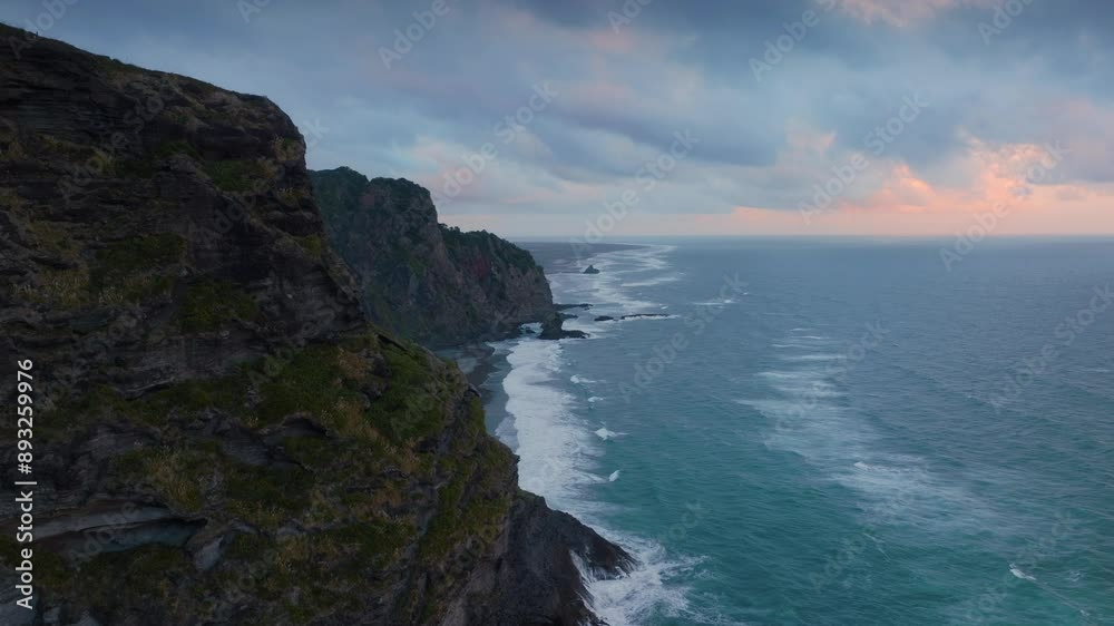 Rocky cliffs of Mercer Bay in the Waitakere Ranges at sunset. Karekare, Auckland, New Zealand. Rocky cliffs of Mercer Bay in the Waitakere Ranges at sunset. Karekare, Auckland, New Zealand.