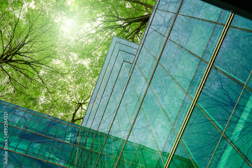 Eco-friendly building in modern city. Sustainable glass office building with trees for reducing carbon dioxide. Office building with green environment. Corporate building reduce CO2. Net zero emission photo