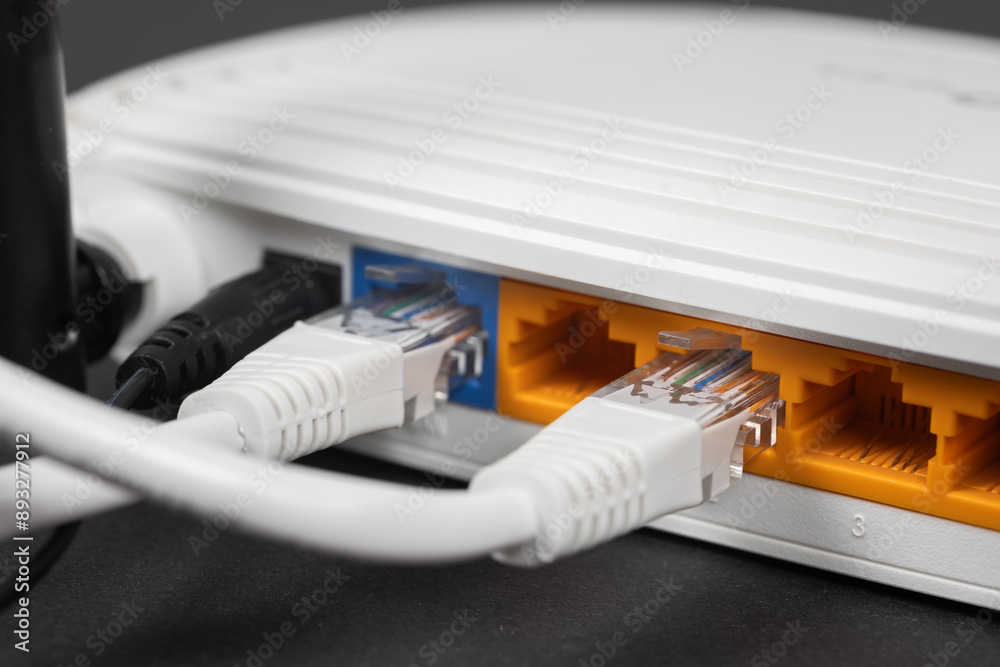 Connect an Ethernet Cable to a Wireless Router on dark. Ethernet, rj45 and electric cables, connected to router.