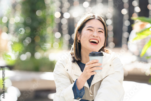 街に座ってコーヒーを片手に大笑いをしている女性