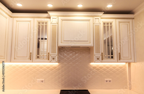 Elegant Kitchen with Recessed Lighting. A classic kitchen featuring elegant cabinets and built-in lighting. LED lights under the cabinets create a cozy atmosphere  photo