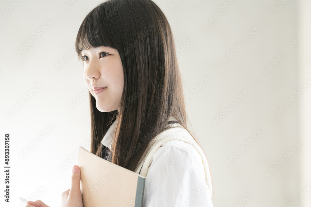 ノートとシャープペンシルを持っている制服姿の女子学生 ノートとシャープペンシルを持っている制服姿の女子学生