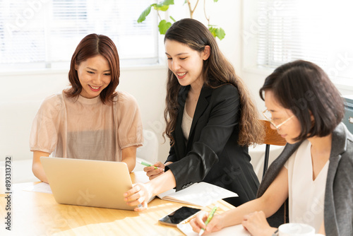 パソコンの前で会話をしている女性たち