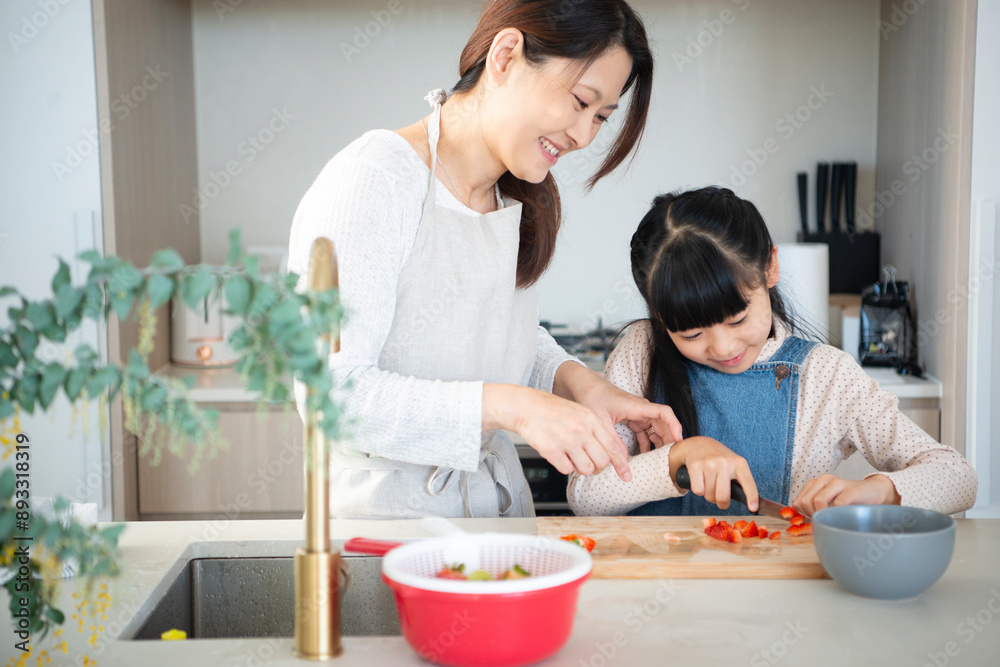 キッチンでお手伝いをしている女の子と母親 キッチンでお手伝いをしている女の子と母親