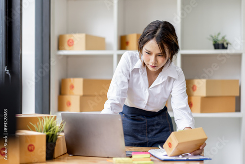 Startup small business entrepreneur SME, asian woman checks stock on clipboard and parcels at home ,Success small business owner online sell marketing delivery, SME e-commerce telemarketing concept