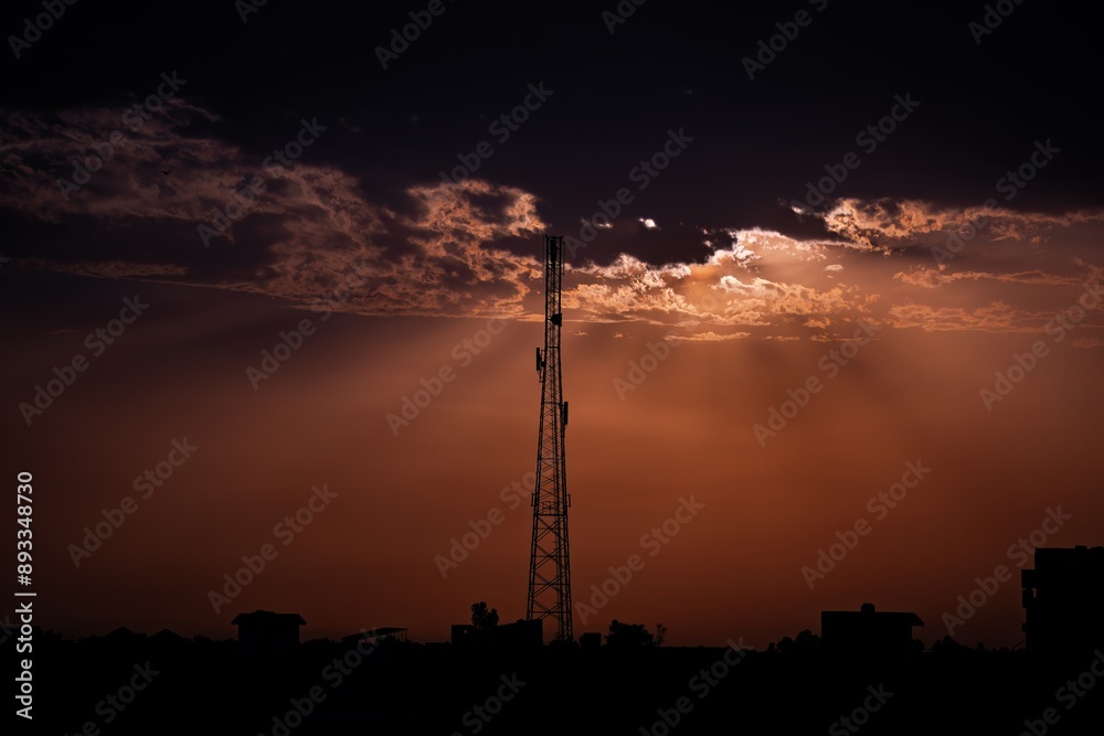 Naklejka premium beautiful sunset with trees, clouds and tower