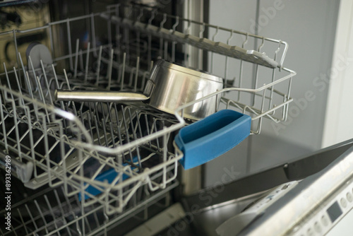 Dishwasher in modern kitchen. Perfectly washing pan. Modern built-in dishwasher with open door in the kitchen at home