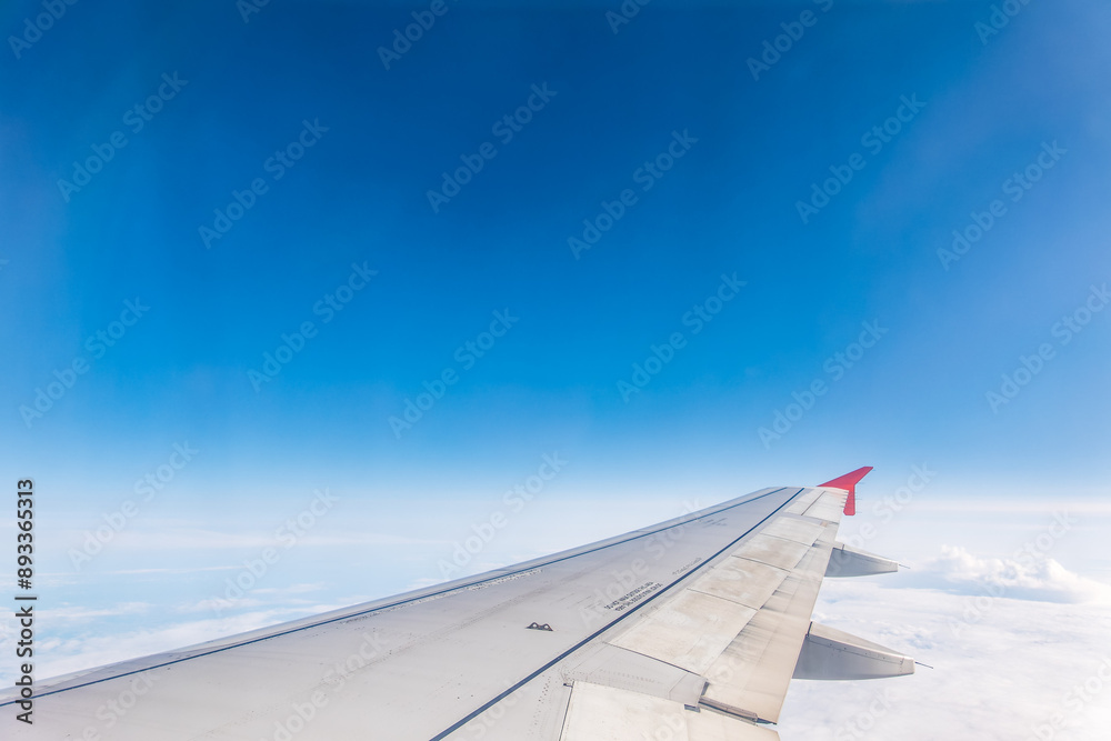 Obraz premium View from the airplane window at a beautiful cloudy sky and the airplane wing