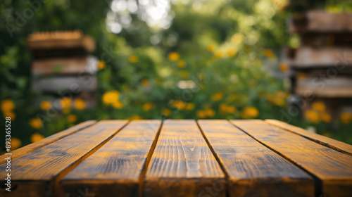 close up of rustic empty wooden table with blurred beehive background © Yin