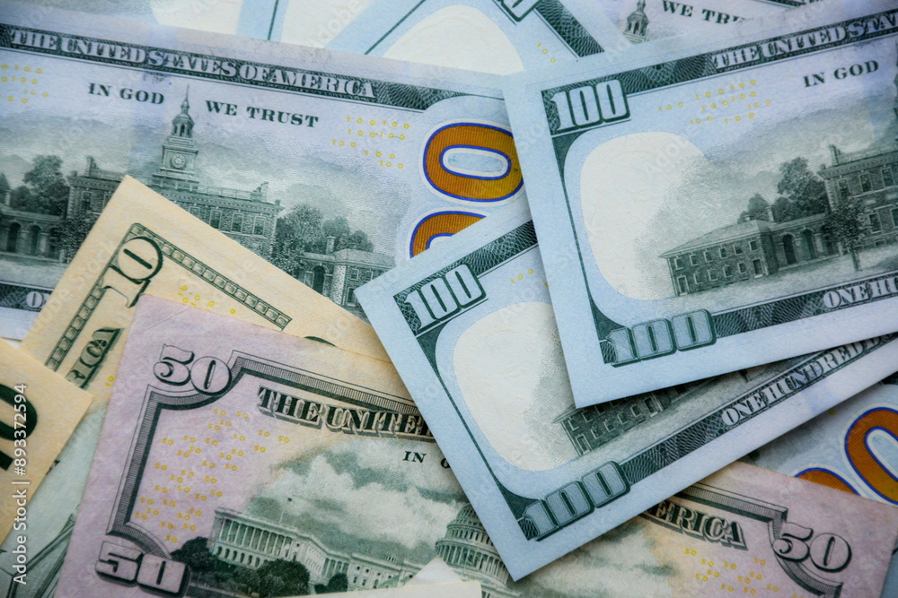 Fototapeta premium Big amount of US dollar bills in different nominations on table. Many dollar banknotes under natural light