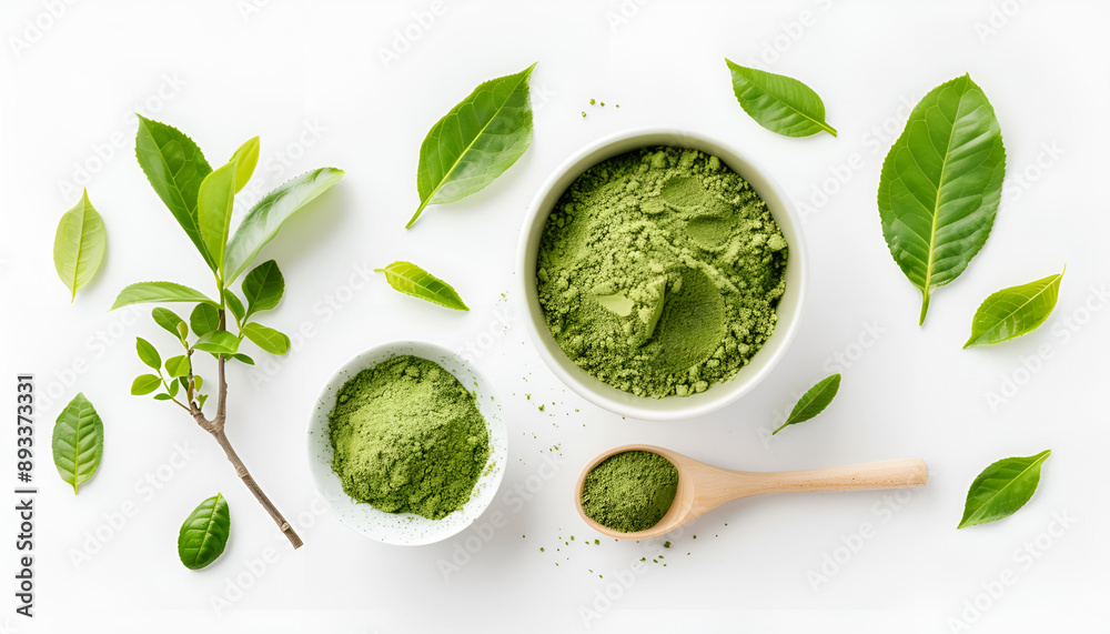 Obraz premium Green matcha powder in bowl, spoon and leaves isolated on white, top view