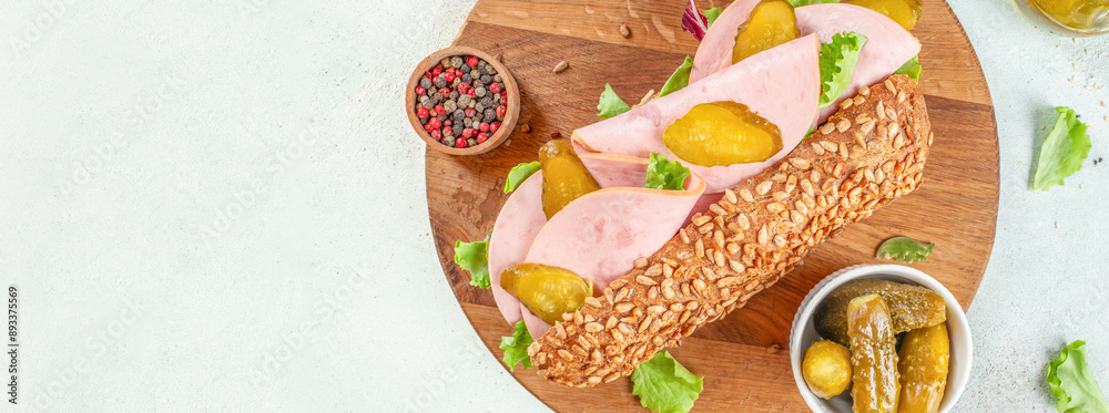 Healthy rye bun sandwiches with ham and pickled cucumbers on a light background top view. copy space Healthy rye bun sandwiches with ham and pickled cucumbers on a light background top view. copy space