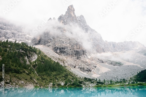 Landscapes of epic mountains during the sunset surrounded by clouds, with warm and cold lights. huge cliffs and epic views from the wild nature. 