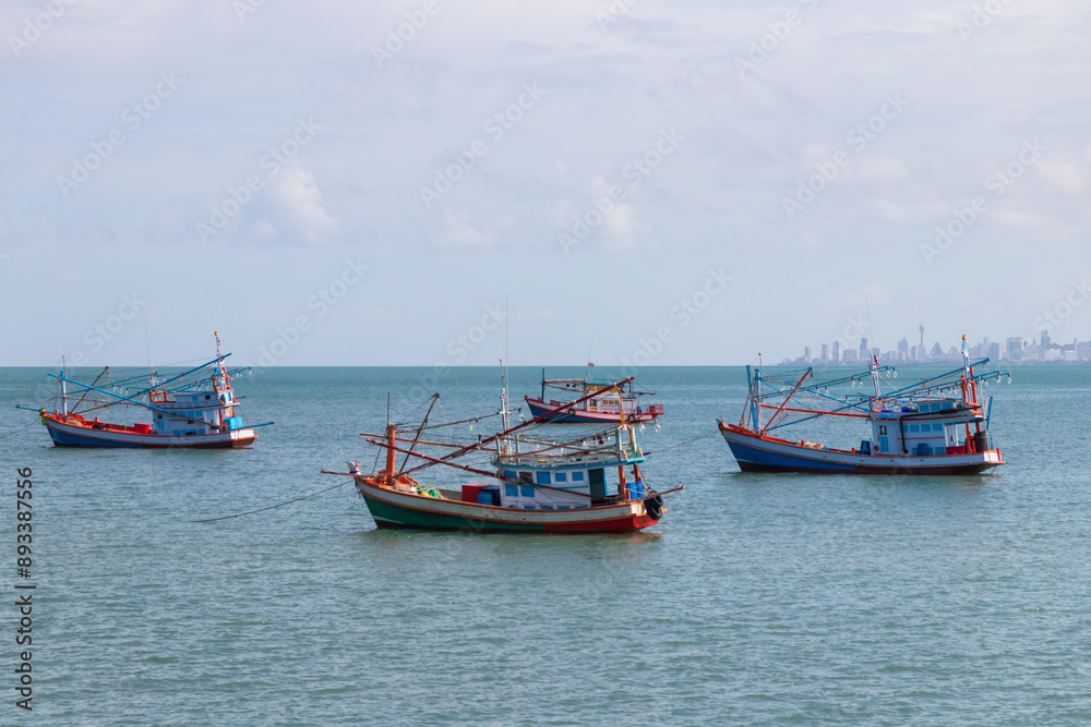 Fishing boat floating on the sea with city on background. Fishing boat floating on the sea with city on background.