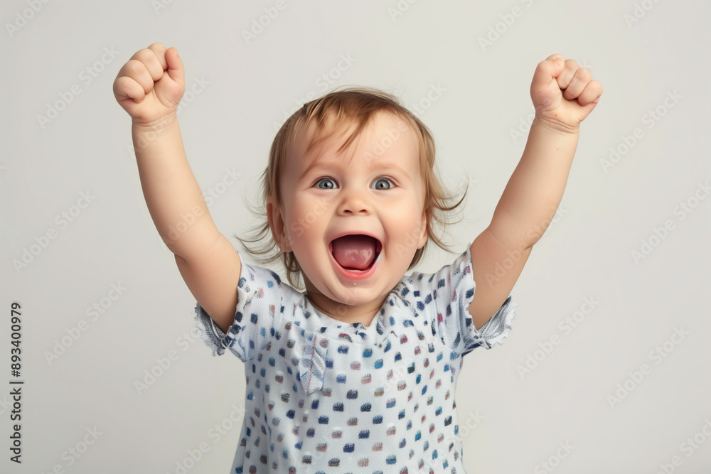 A happy toddler is expressing pure joy, raising arms in celebration with a big smile on their face A happy toddler is expressing pure joy, raising arms in celebration with a big smile on their face