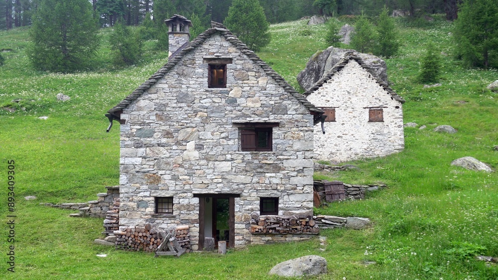 mountain house in the mountain pasture in the Italian and Swiss Alps with stone walls and wooden beams, typical high altitude mountain house
