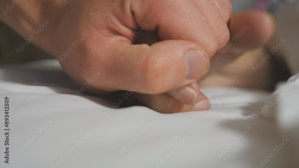 Grandson takes and gently touches hand of his elderly grandmother lying in bed hospital. Young man comforts wrinkled arm of sick mature woman in medical clinic. Concept of care and love. Slow motion Grandson takes and gently touches hand of his elderly grandmother lying in bed hospital. Young man comforts wrinkled arm of sick mature woman in medical clinic. Concept of care and love. Slow motion