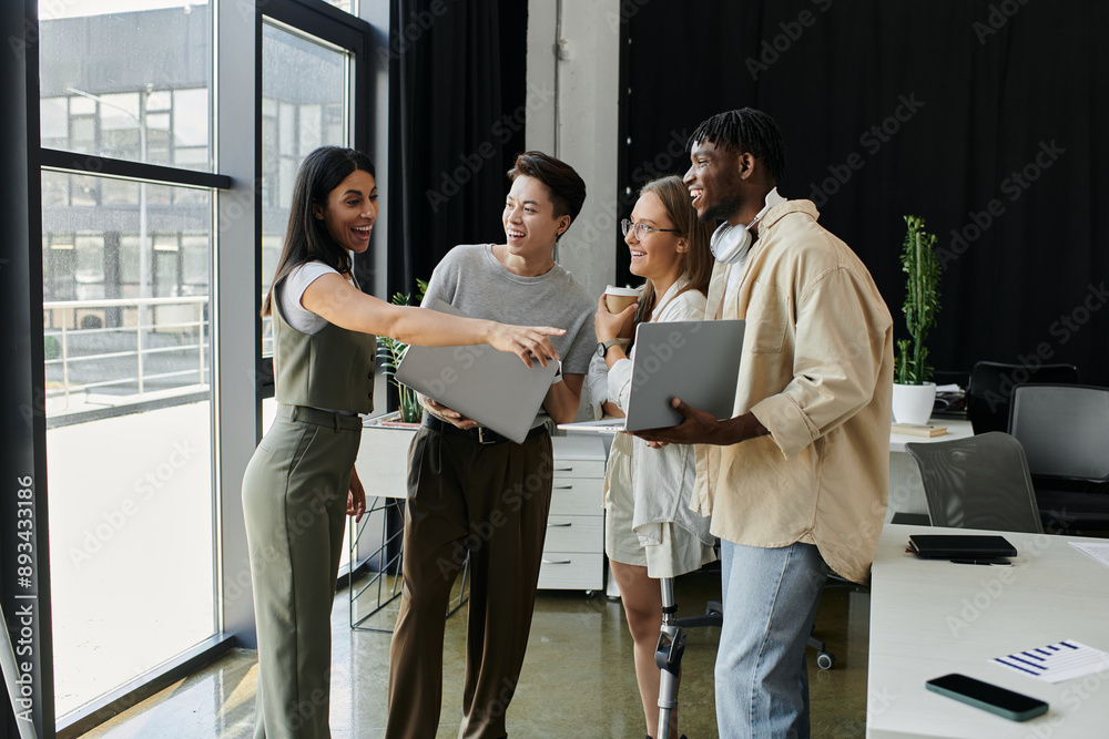 Four colleagues discuss ideas in a bright office space. Four colleagues discuss ideas in a bright office space.