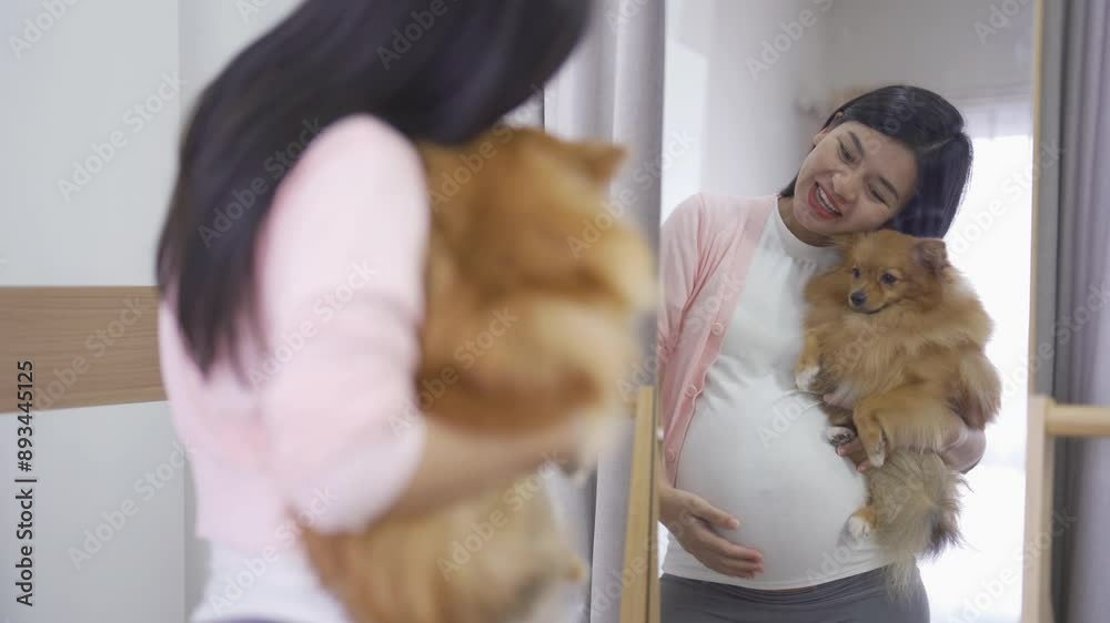 A portrait of happy Asian pregnant woman with domestic dog pet animal in bedroom at home. Having a baby. Family people lifestyle. Mom love. A portrait of happy Asian pregnant woman with domestic dog pet animal in bedroom at home. Having a baby. Family people lifestyle. Mom love.