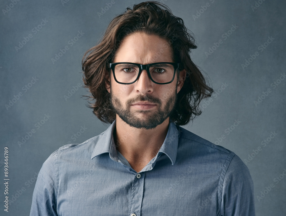 Glasses, portrait or serious and business man in studio on gray background with mean or tough expression. Eyewear, face and vision with assertive employee in shirt for professional job or work Glasses, portrait or serious and business man in studio on gray background with mean or tough expression. Eyewear, face and vision with assertive employee in shirt for professional job or work