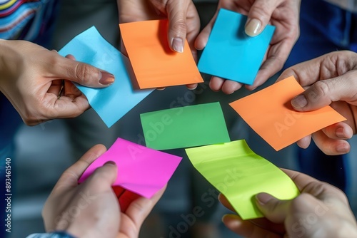 Colorful sticky notes held by diverse hands in collaboration, representing brainstorming, team work, and creativity.